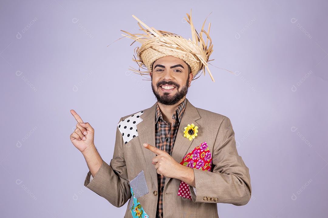 Jovem quadrilheiro animado para festa junina apontando para o lado