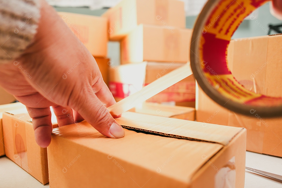 Caixa de encomenda mão passando fita na caixa
