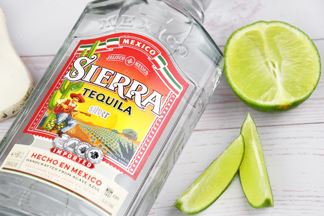 Garrafa de tequila Sierra com limão sobre fundo claro