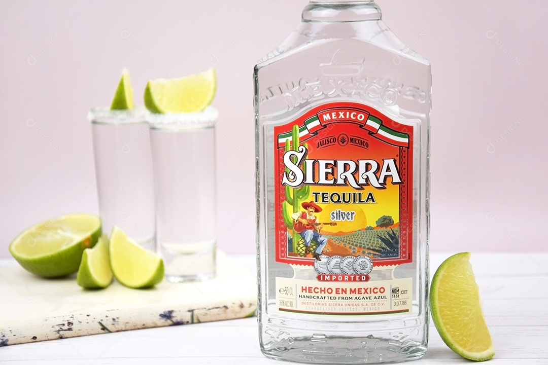 Garrafa de tequila Sierra com copo de shots sobre fundo claro