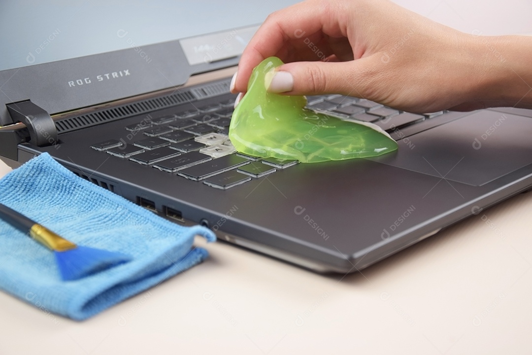 Mão segurando gel de limpeza para teclado