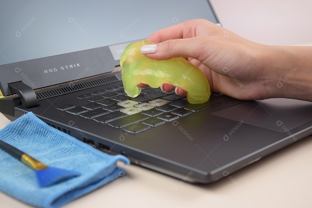 Mão com gel de limpeza para teclado
