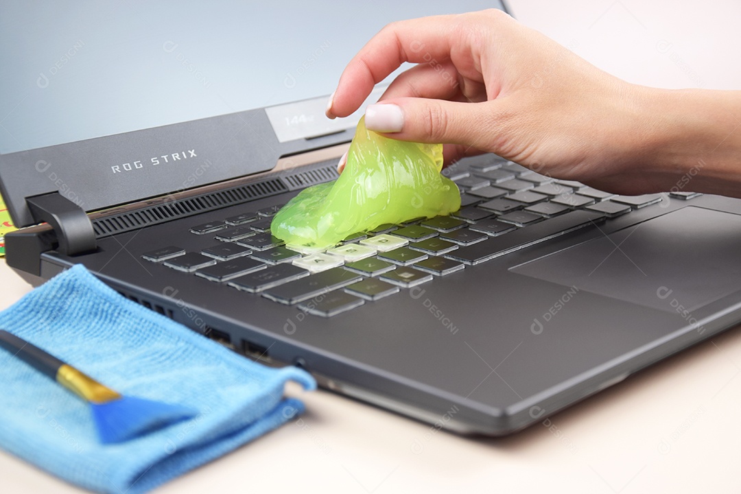 Mão segurando gel de limpeza para teclado