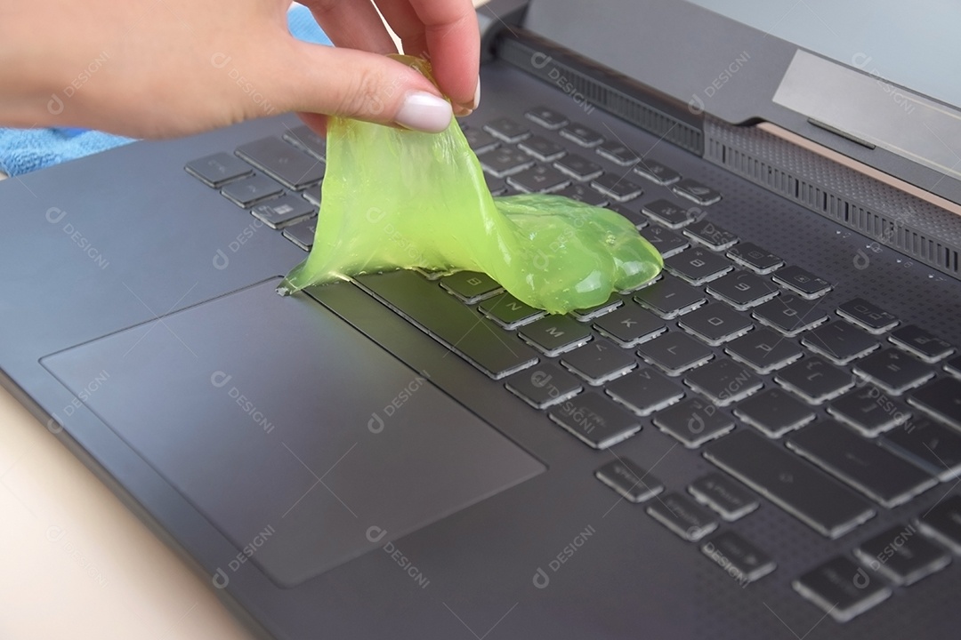 Mão segurando gel de limpeza para teclado