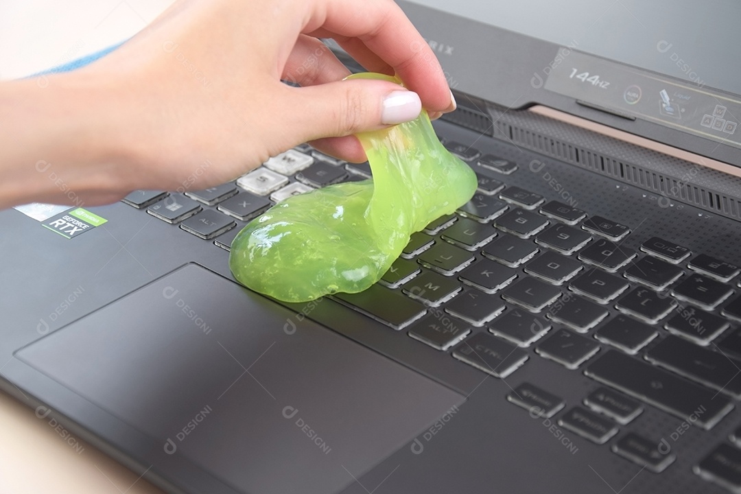 Mão segurando gel de limpeza para teclado