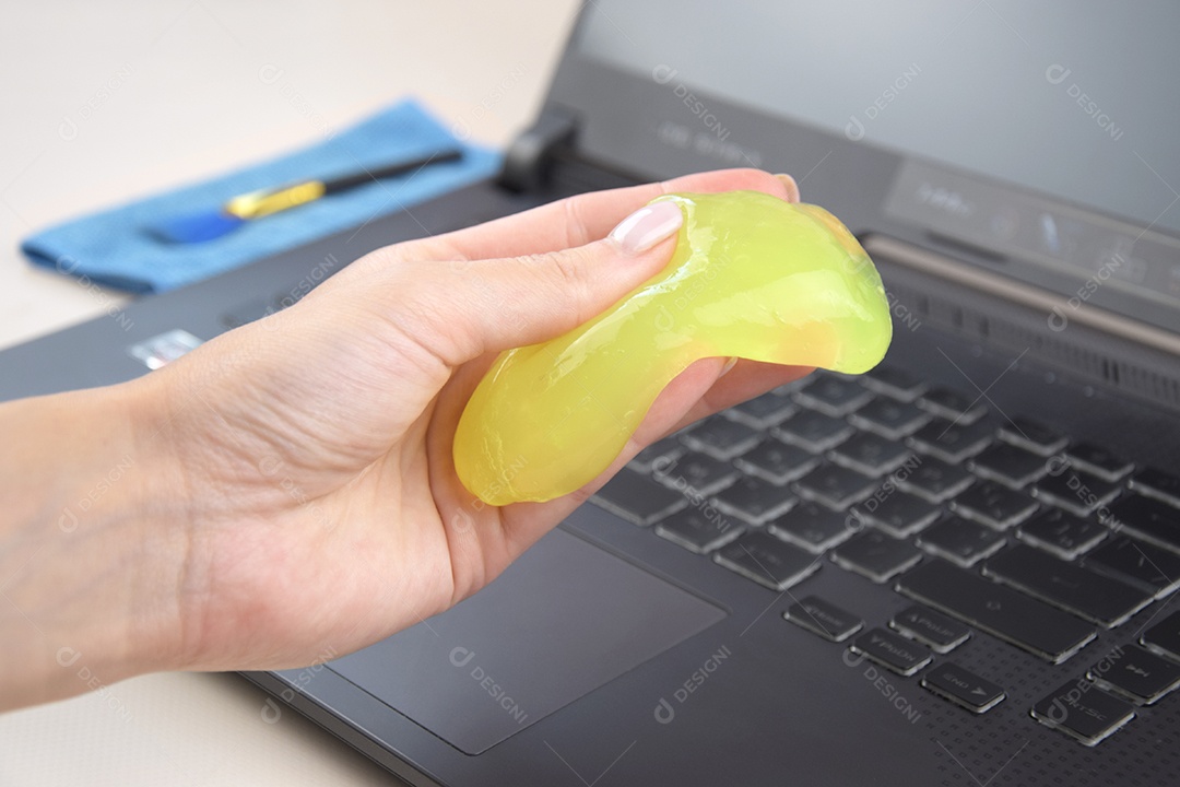 Mão segurando gel de limpeza para teclado