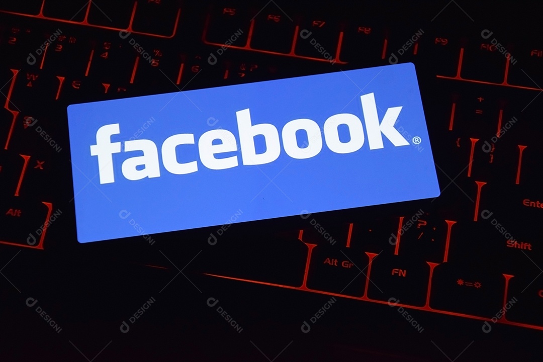 Teclado com fundo de vermelho e celular com aplicativo do facebook