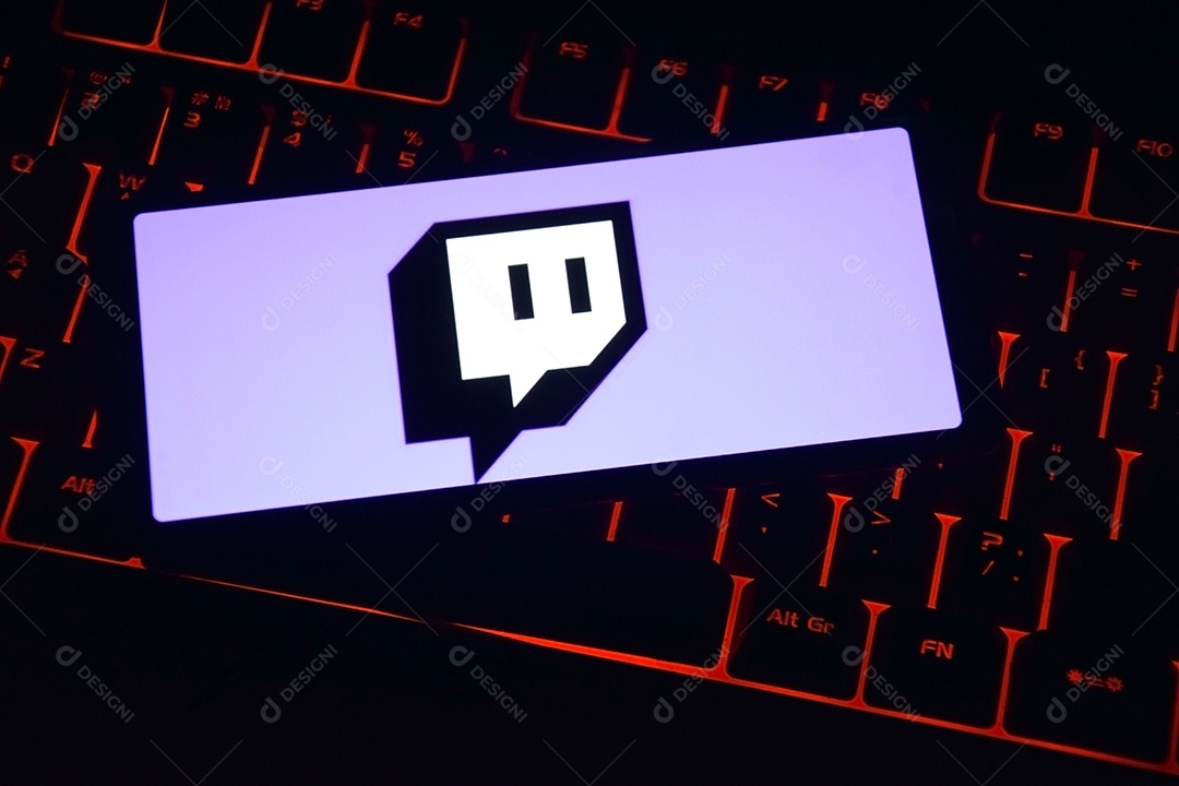 Celular com tela aberta em twitch sobre um teclado com luzes vermelha