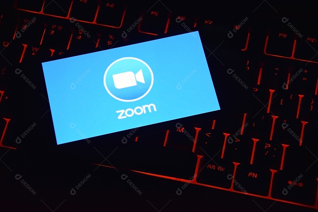 Teclado com luzes vermelha e celular com aplicativo zoom