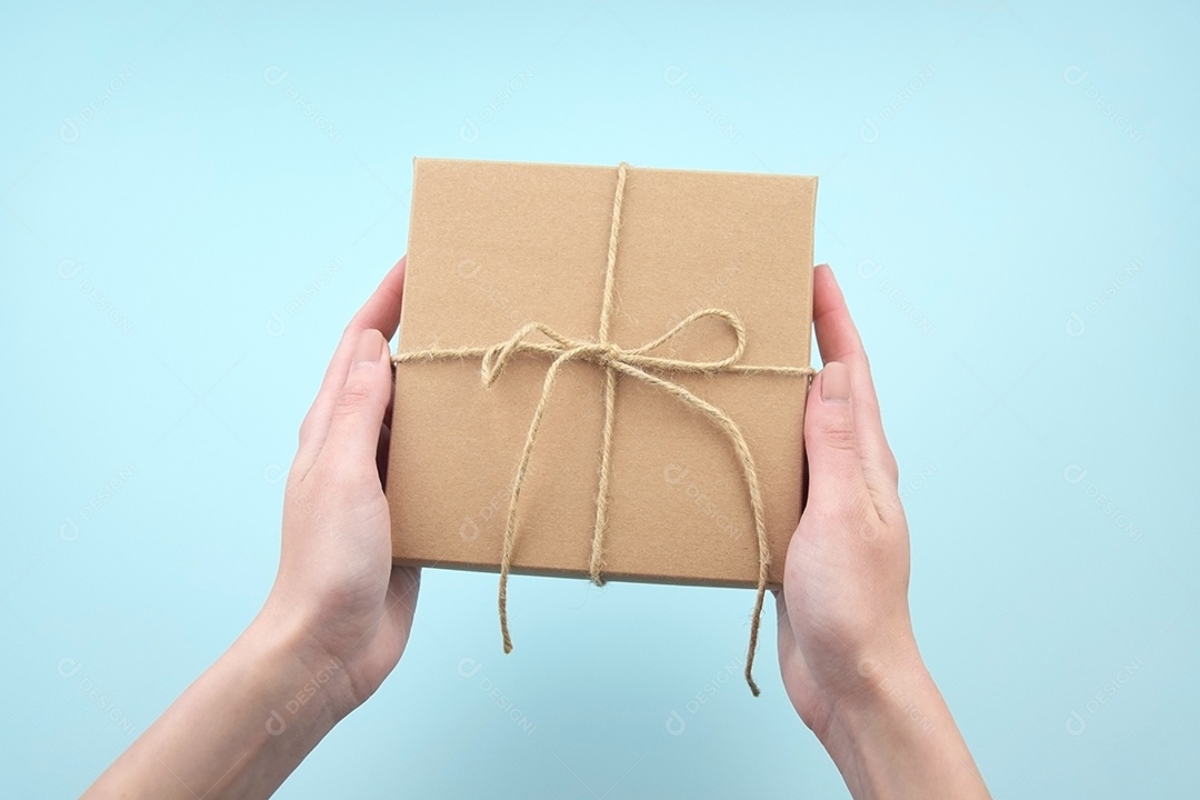 Mãos segurando caixa para presente