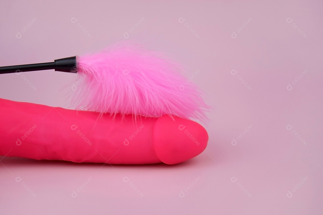 Vibrador de borracha rosa com pena ao lado
