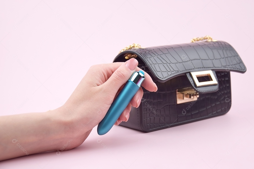 Bolsa preta linda e mão segurando vibrador