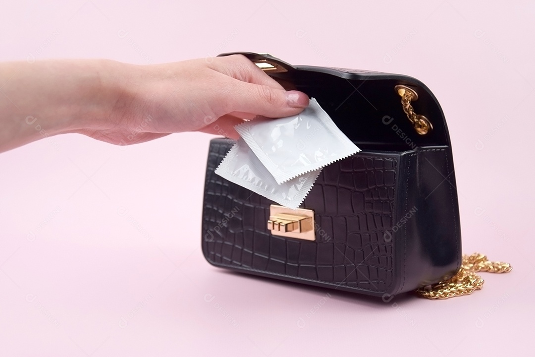 Bolsa preta com mão guardando camisinhas