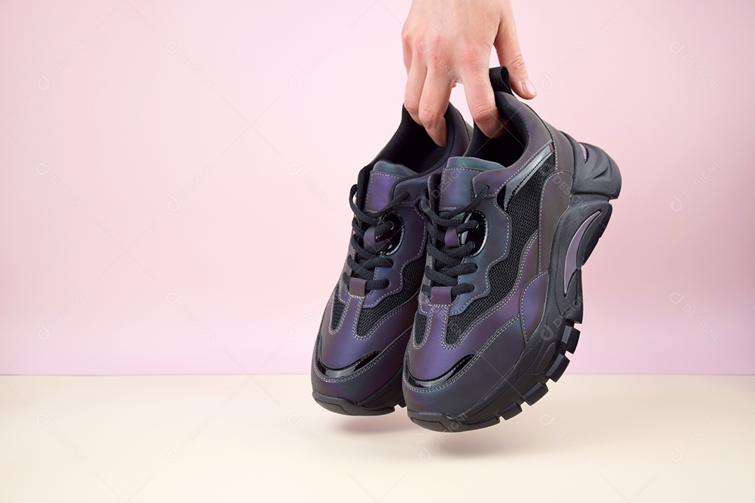 Mãos segurando tênis sneaker
