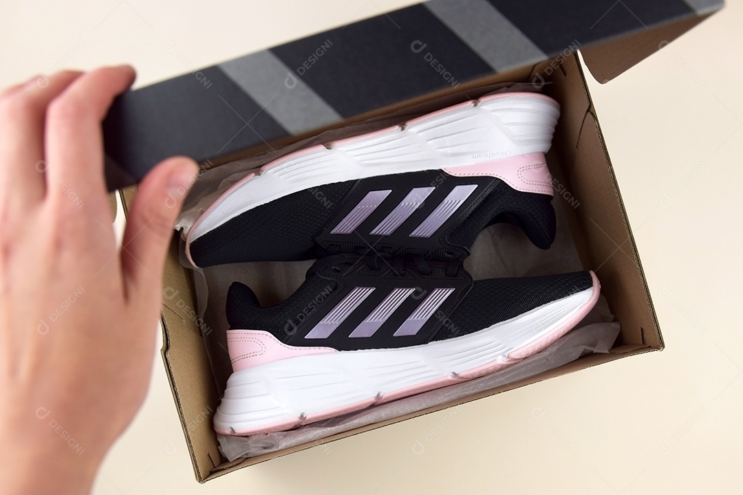 Mão abrindo caixa de sapatos