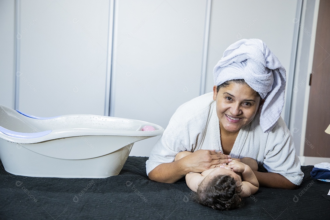 Mãe feliz com seu bebê na cama
