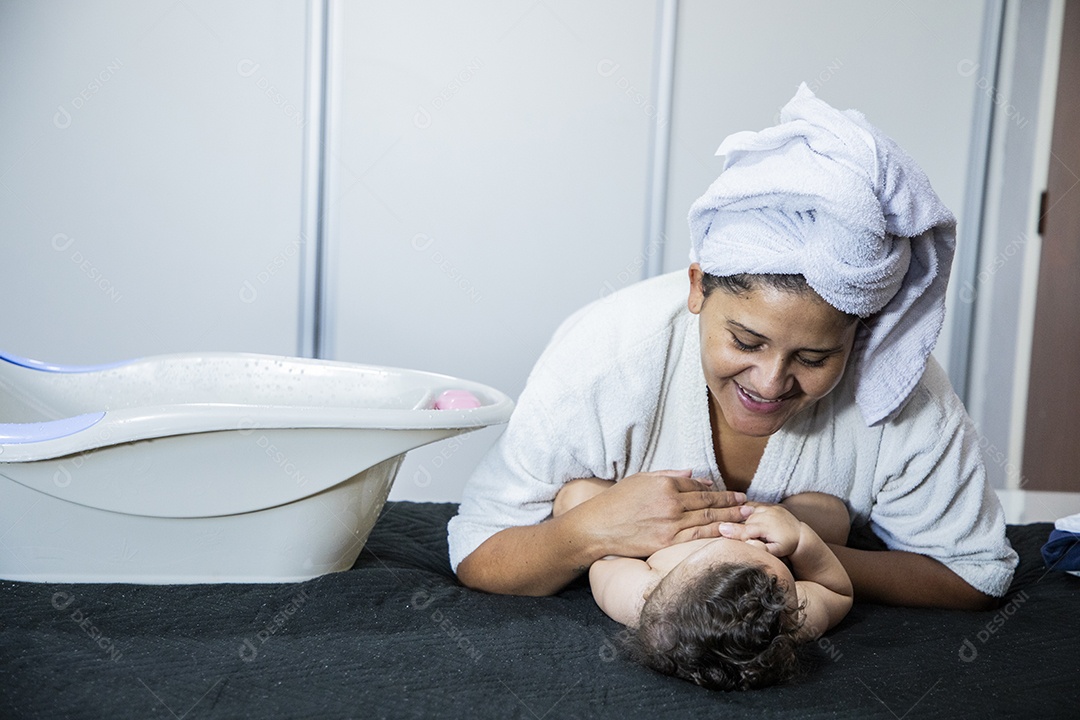 Mãe brincando com seu bebê na cama