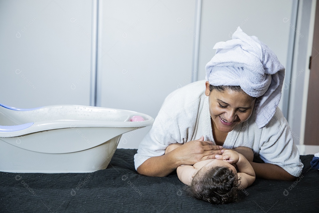 Mãe brincando com seu bebê na cama