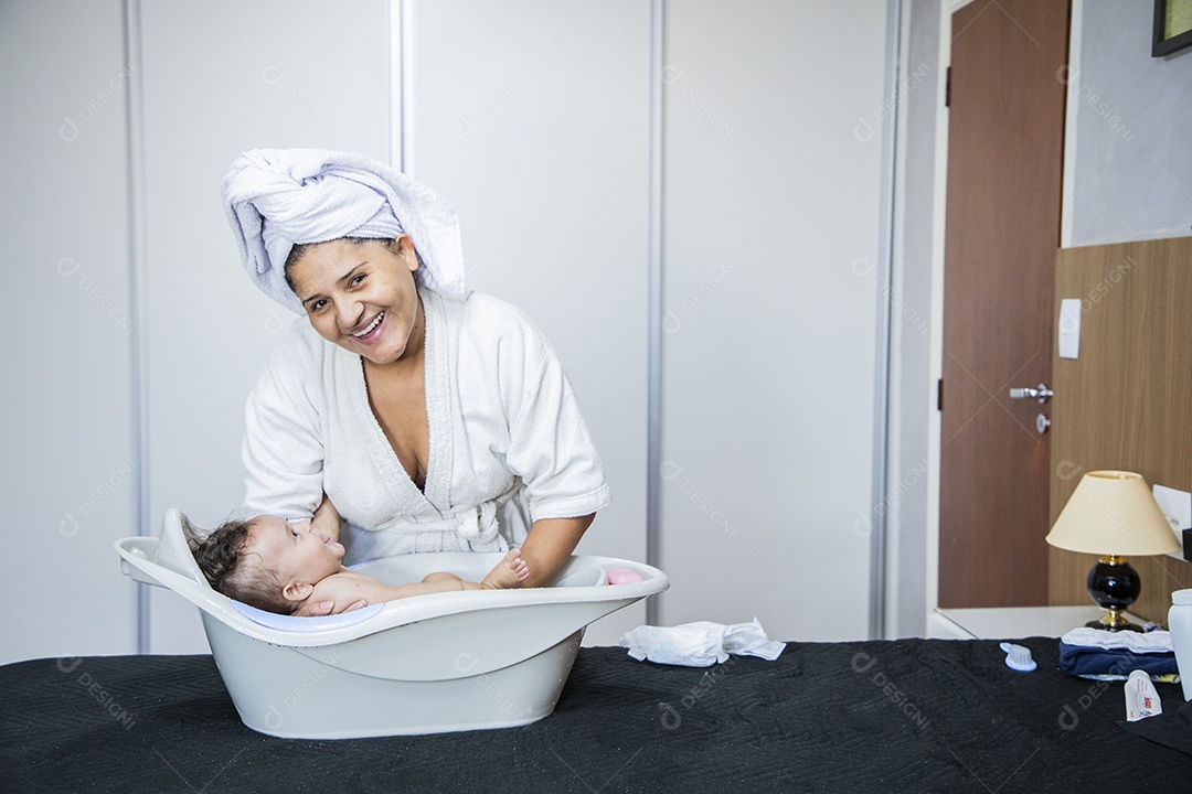Mulher banhando seu bebê felizes