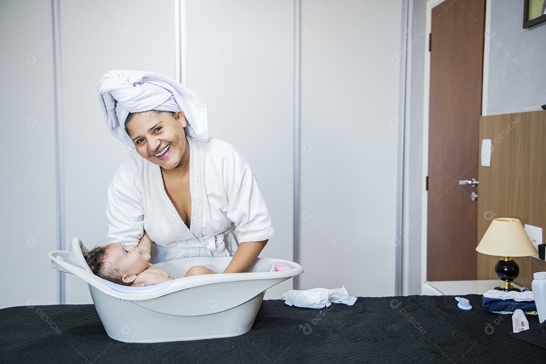 Mulher banhando seu bebê felizes