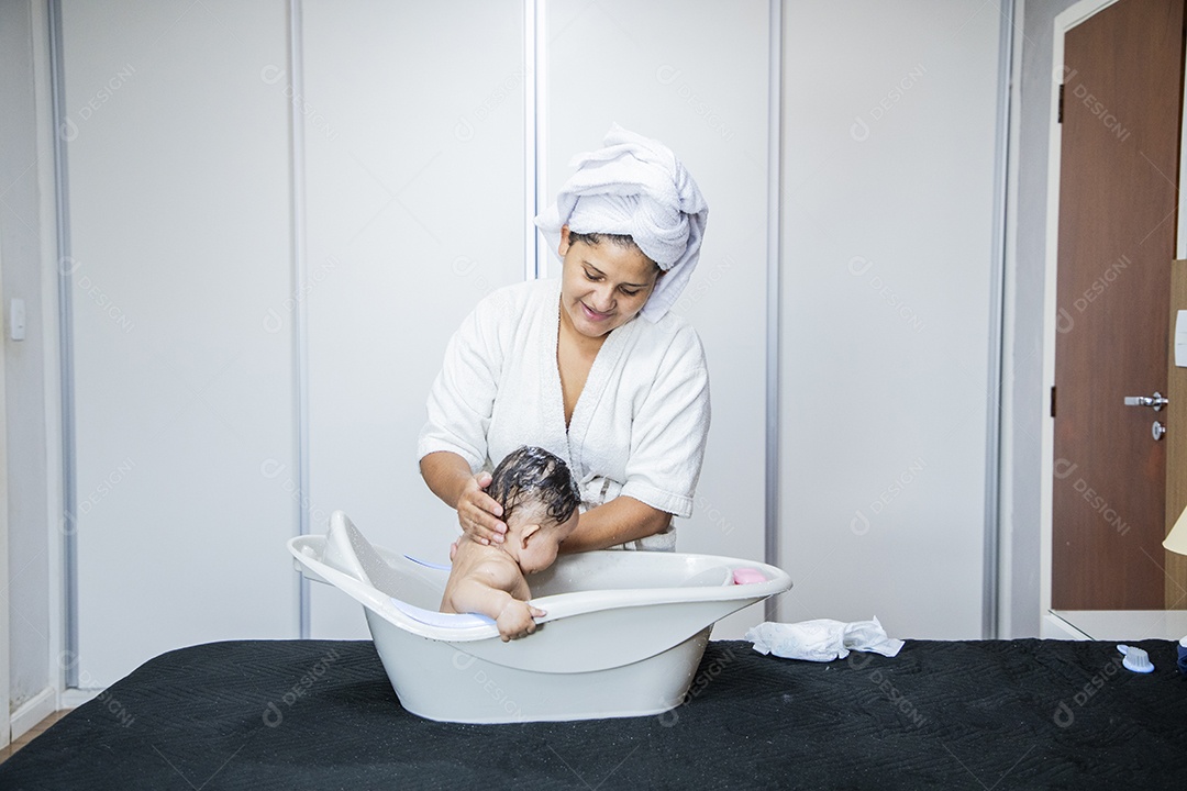 Mulher banhando seu bebê felizes