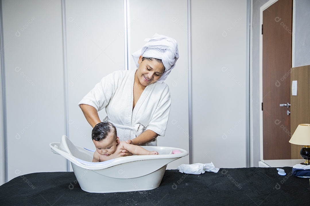 Mulher banhando seu bebê felizes