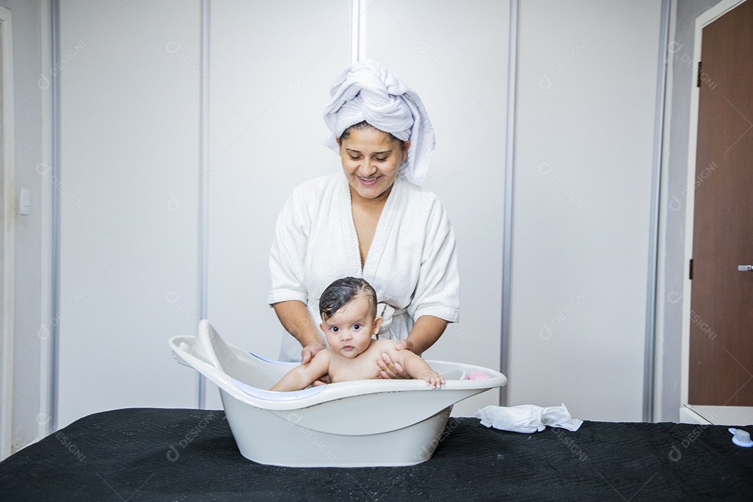 Mulher banhando seu bebê felizes