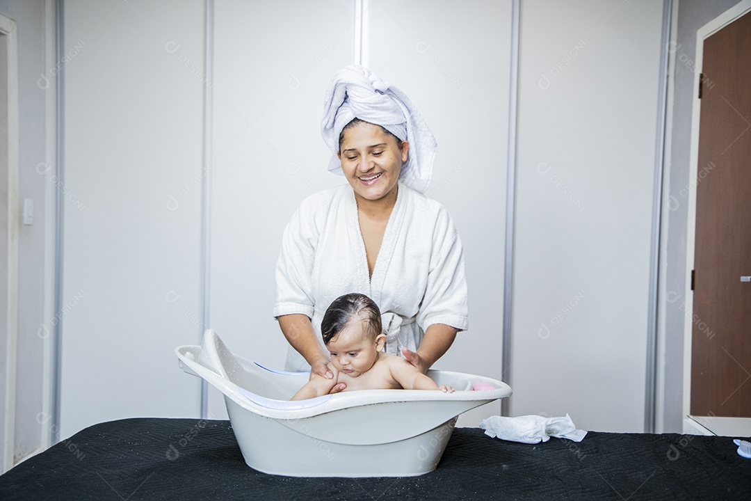 Mulher banhando seu bebê felizes