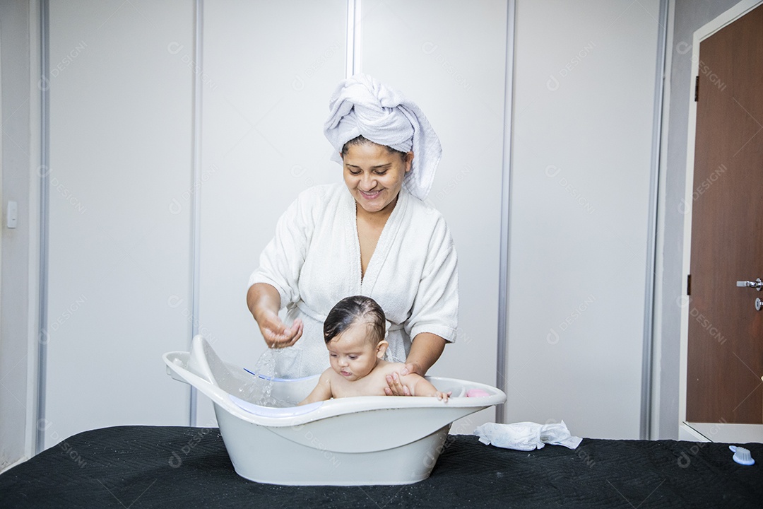 Mulher banhando seu bebê felizes
