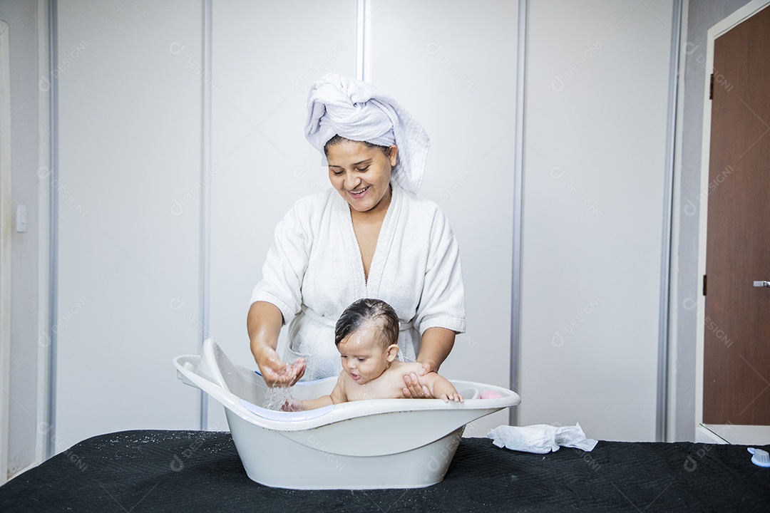 Mulher banhando seu bebê felizes
