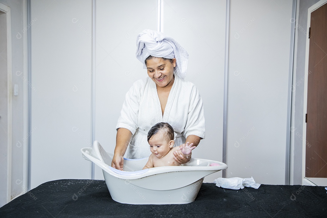 Mulher banhando seu bebê felizes