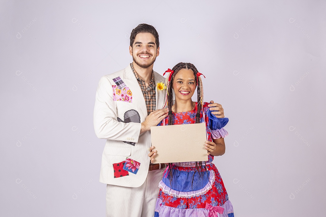 Casal de quadrilheiros trajados para festa junina segurando plaquinha