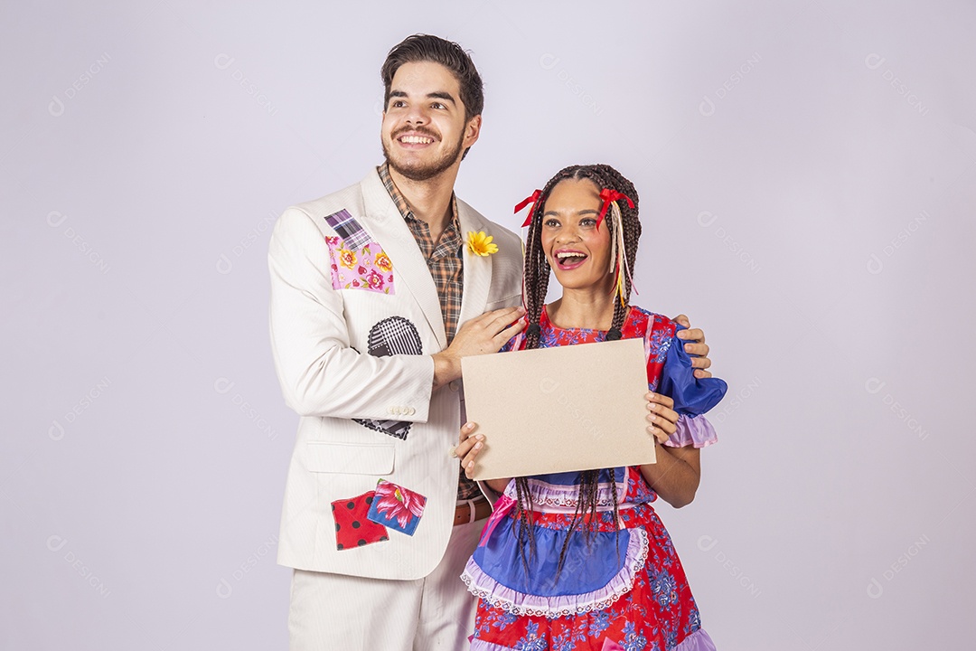 Casal de quadrilheiros trajados para festa junina segurando plaquinha