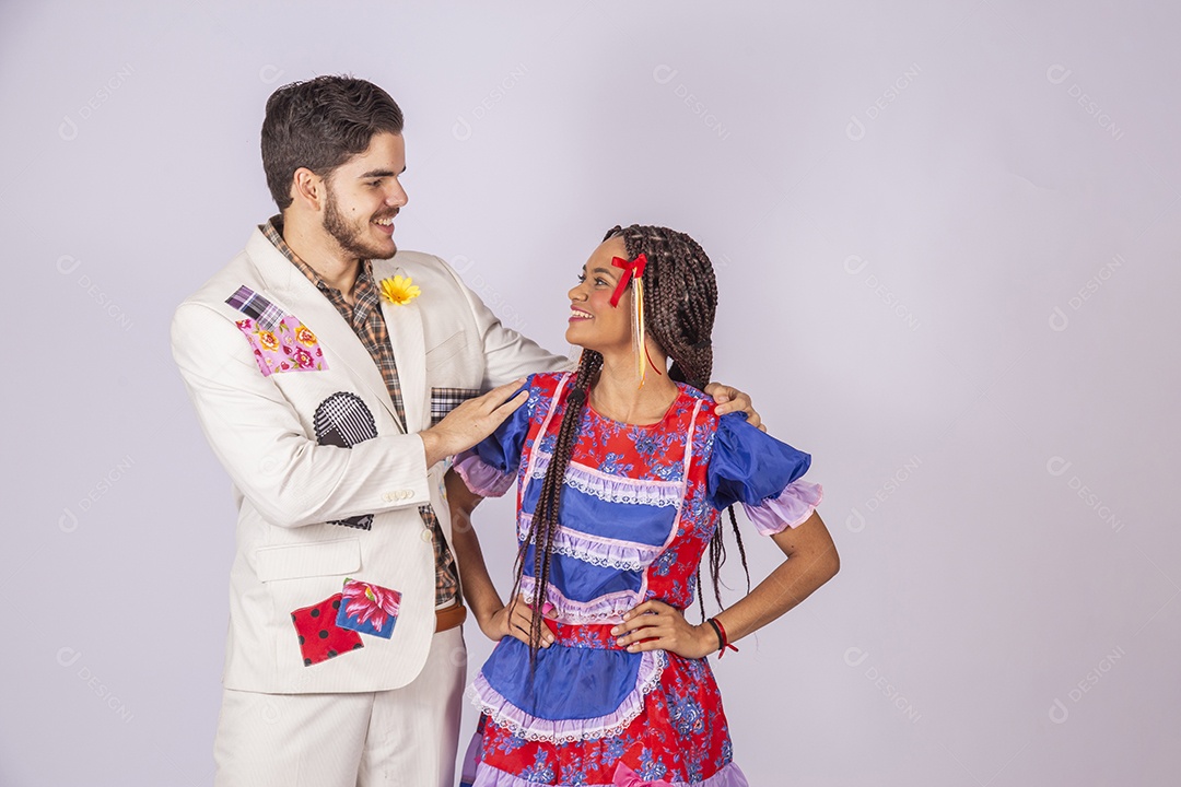 Casal trajado para festa junina se olhando e sorrindo