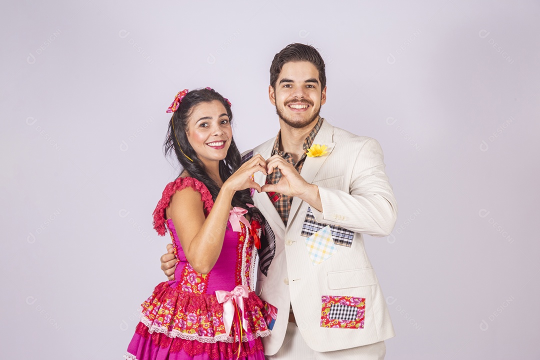 Casal a caráter para festa de São João abraçados fazendo coração