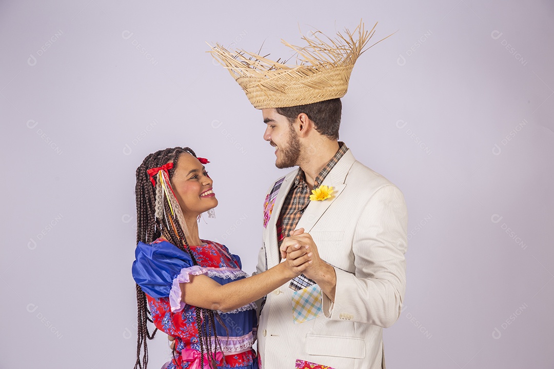 Casal de quadrilheiros juninos de mãos dadas