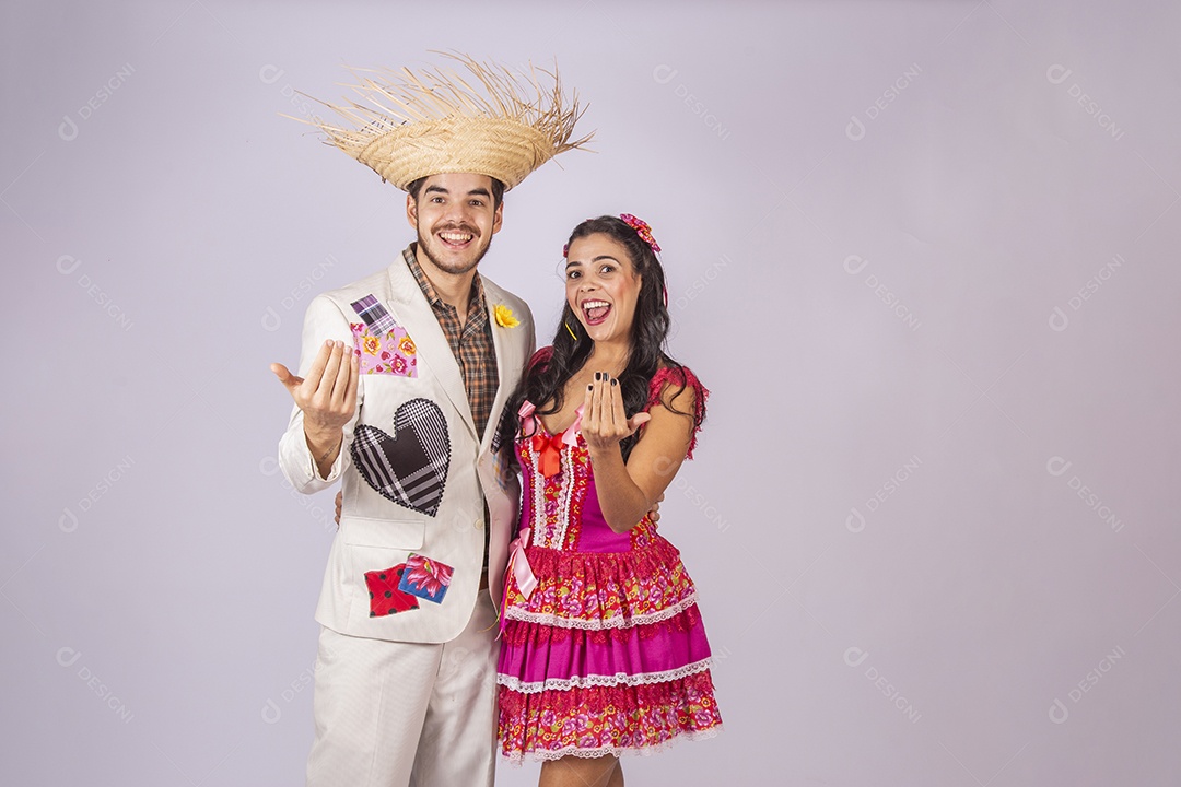 Casal de quadrilheiros juninos com gesto chamando e sorrindo