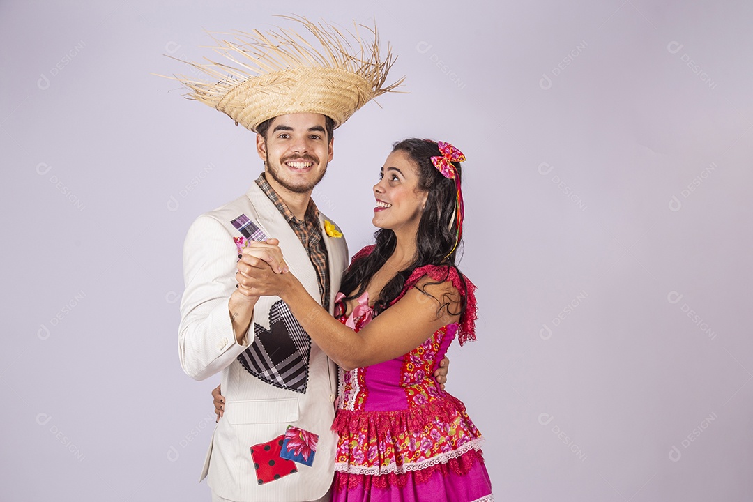 Casal de quadrilheiros de braços dados e sorrindo