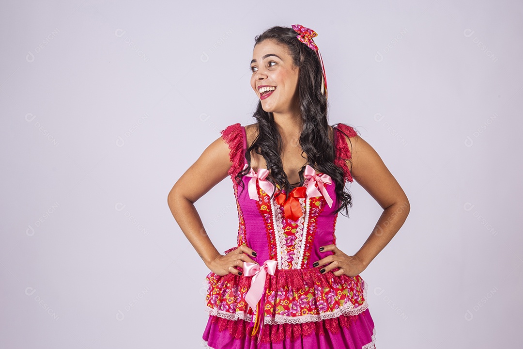 Mulher trajada para quadrilha sorrindo com mãos na cintura