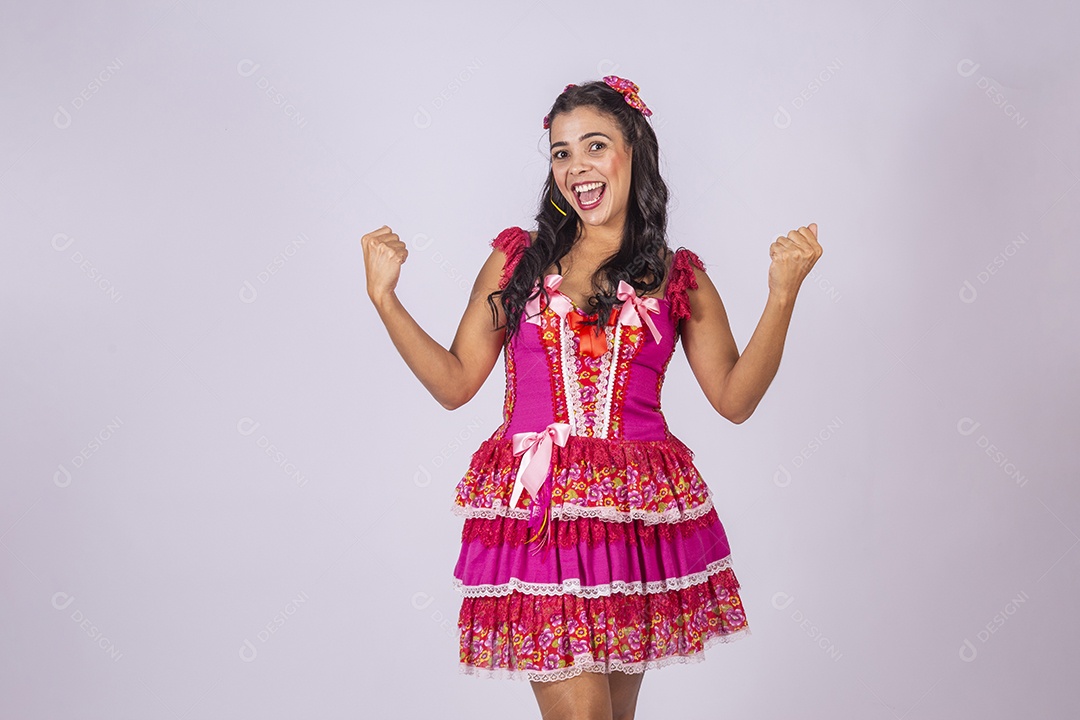 Mulher trajada para quadrilha junina com mãos para cima e sorrindo