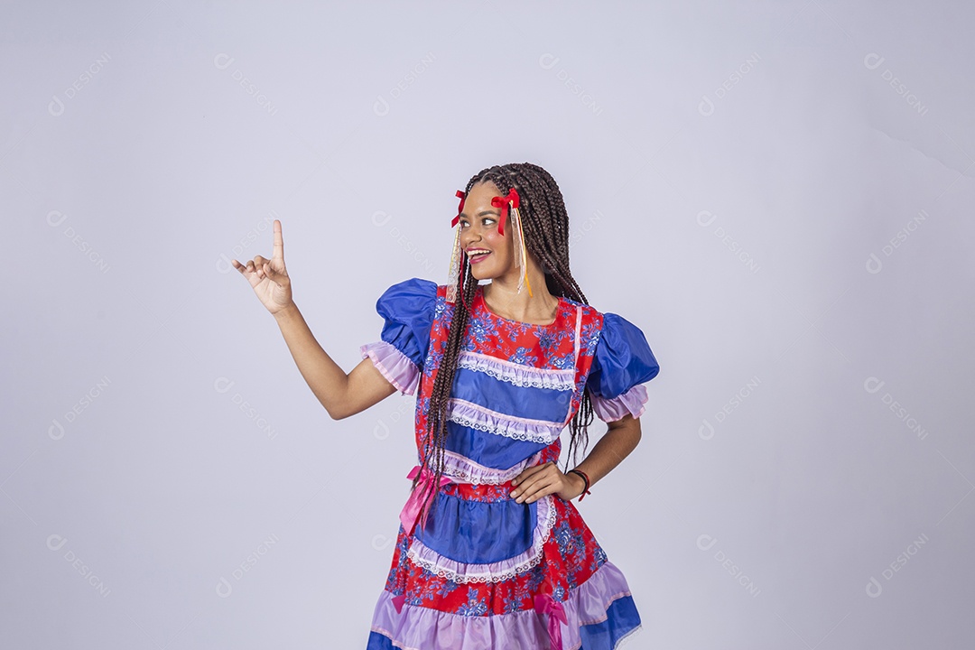 Mulher trajada para quadrilha junina apontando para cima