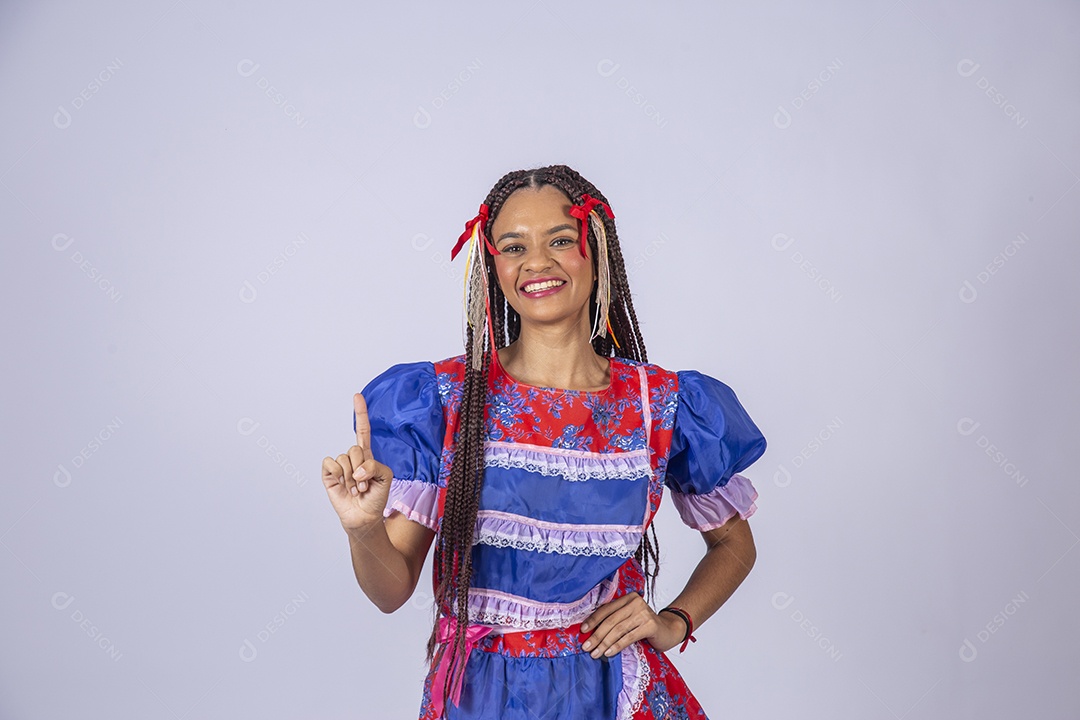 Mulher trajada para quadrilha junina apontando para cima