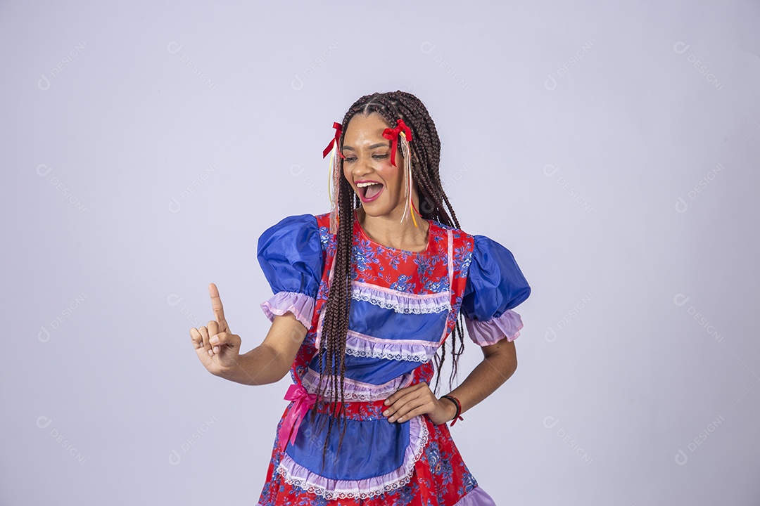 Mulher trajada para quadrilha junina apontando para cima