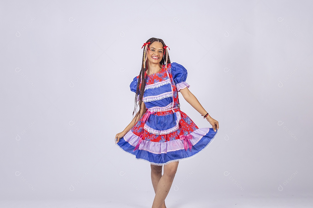 Jovem vestida de trajes juninos segurando no vestido