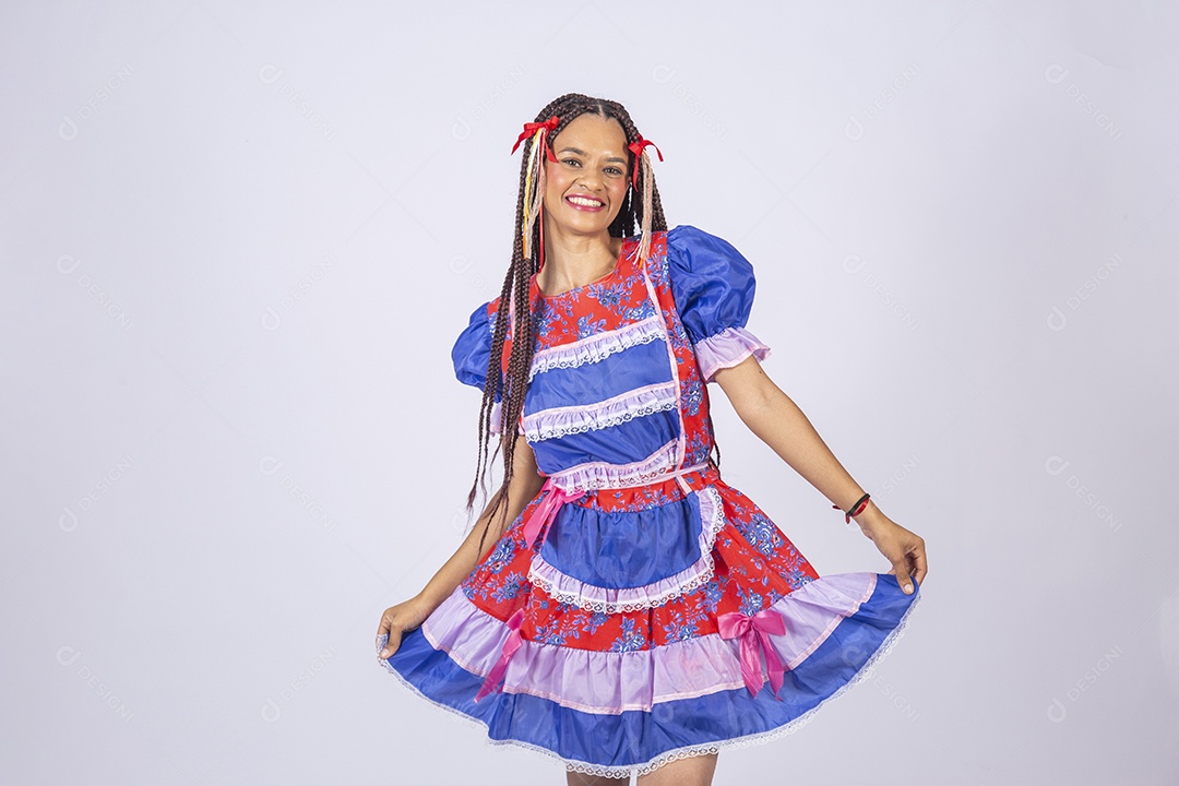 Jovem vestida de trajes juninos segurando no vestido