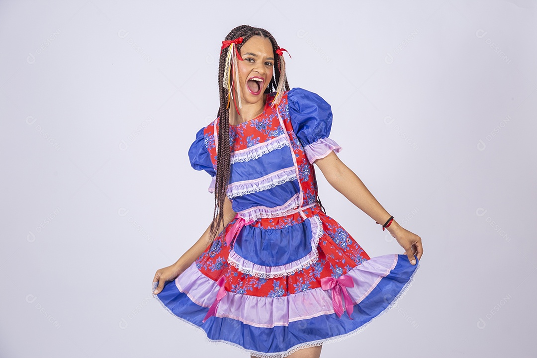 Jovem vestida de trajes juninos segurando no vestido