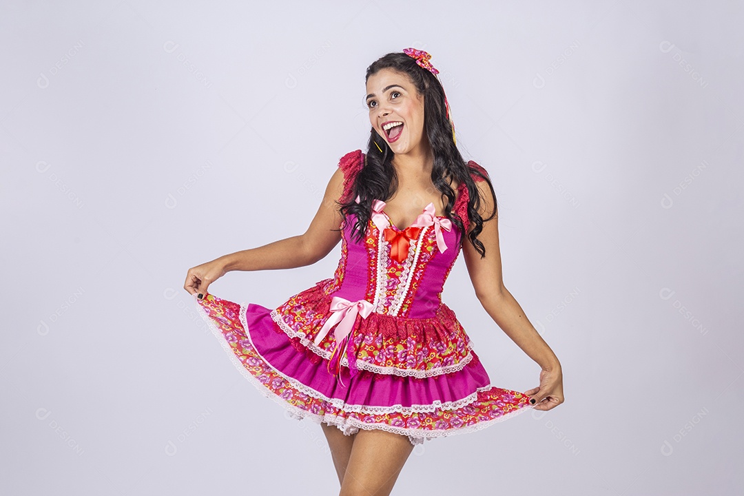 Jovem vestida de trajes juninos segurando no vestido