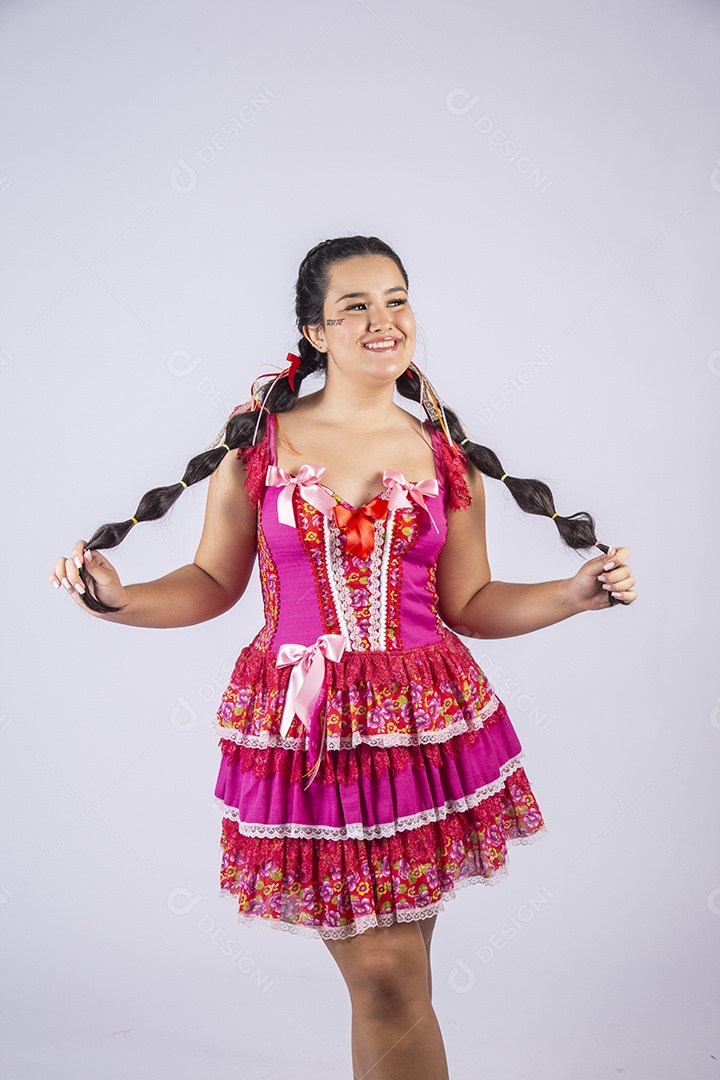 Mulher quadrilheira vestida para festa junina sorrindo com mãos na cintura