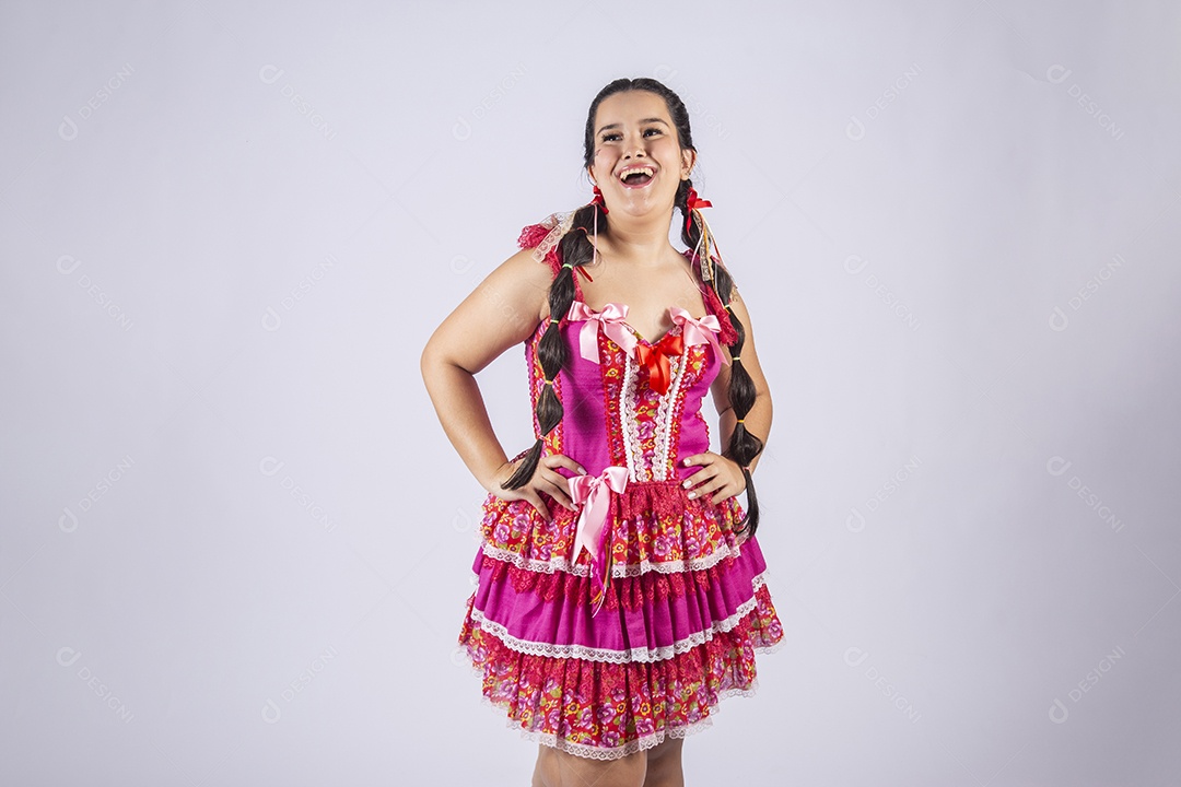 Mulher vestida de trajes junino com mãos na cintura e sorrindo