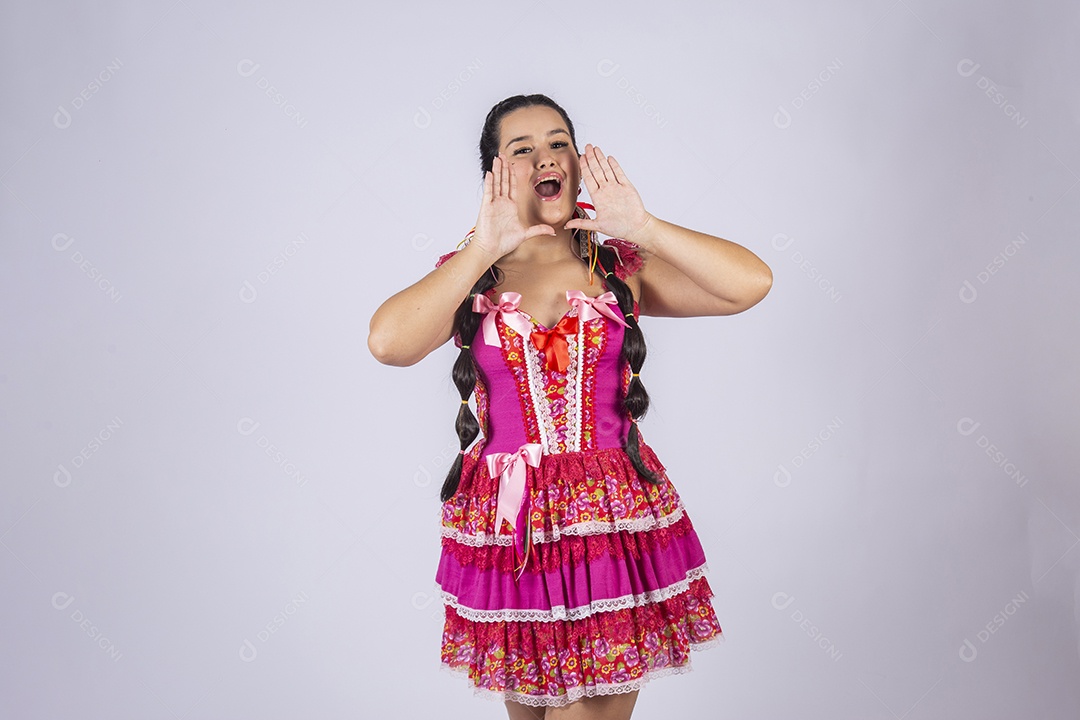 Mulher vestida de trajes junino com mãos na boca gritando